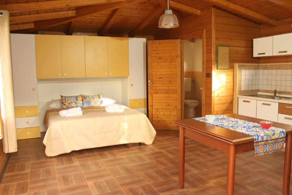 a bedroom with a bed and a table and a kitchen at Il giardino di Mondello in Mondello