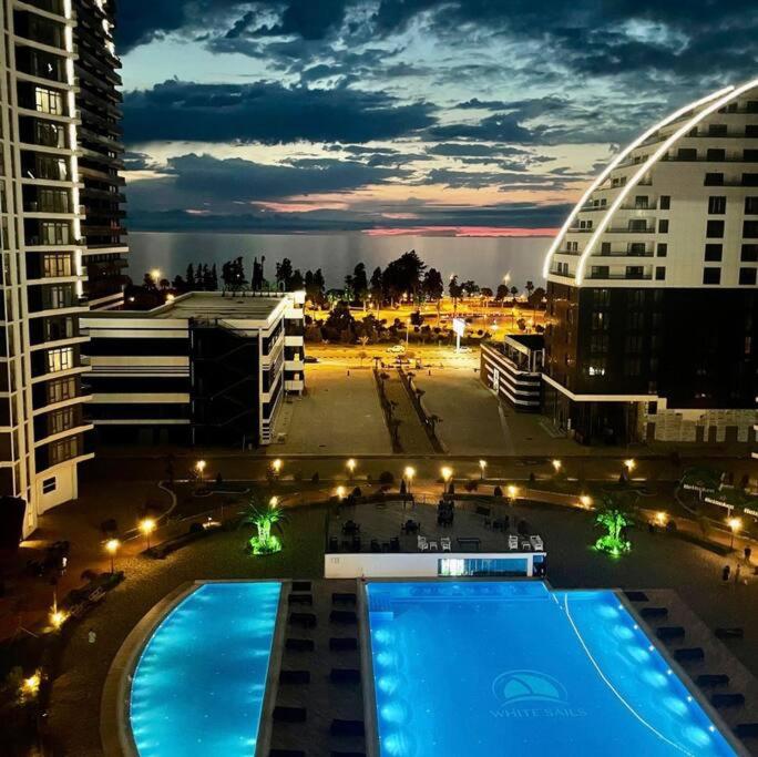 vista para uma piscina numa cidade à noite em Nessy's Apartment 