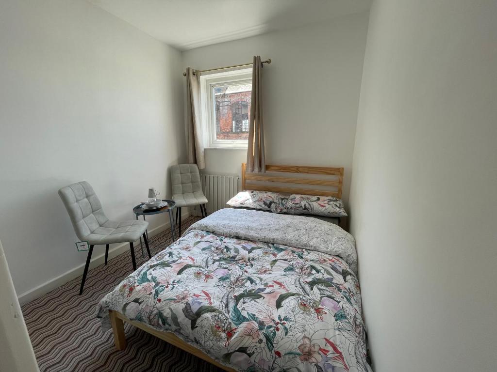 - une chambre avec un lit, un miroir et une chaise dans l'établissement Nottingham Home Stay, à Nottingham