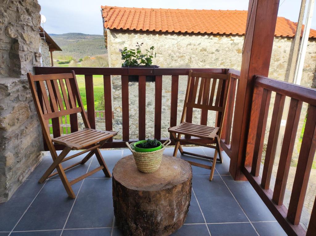 a balcony with two chairs and a tree stump at Recanto da Encosta - T2 in Bragança