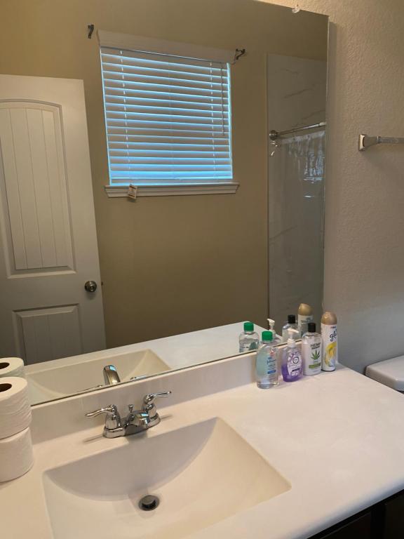 een badkamer met een wastafel en een grote spiegel bij Kenny Place Park row Katy, Texas in Katy