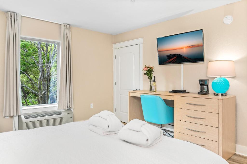 um quarto com uma secretária e uma cama com uma cadeira azul em Gold Coast Inn Breathtaking Sunsets 2 Bdr Garden View Deluxe Suite 209 em Traverse City