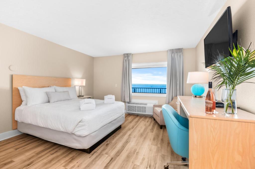 Pokój hotelowy z łóżkiem, biurkiem i telewizorem w obiekcie Gold Coast Inn Breathtaking Sunsets Standard Lake View Room 307 w mieście Traverse City