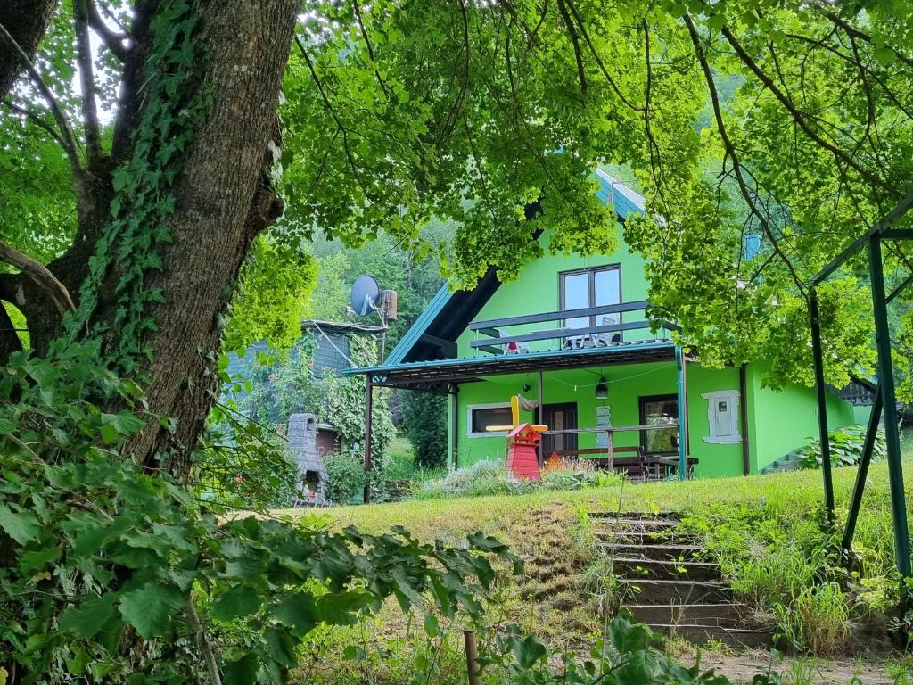 ein grünes Haus mit Treppe davor in der Unterkunft Private beach holiday home Ilan in Kulen Vakuf