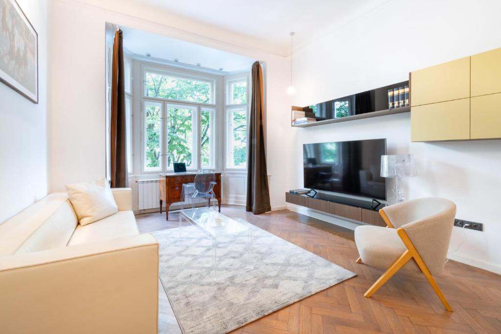 a living room with a white couch and a tv at Elegant Paris Ave apartment with a Terrace in Prague