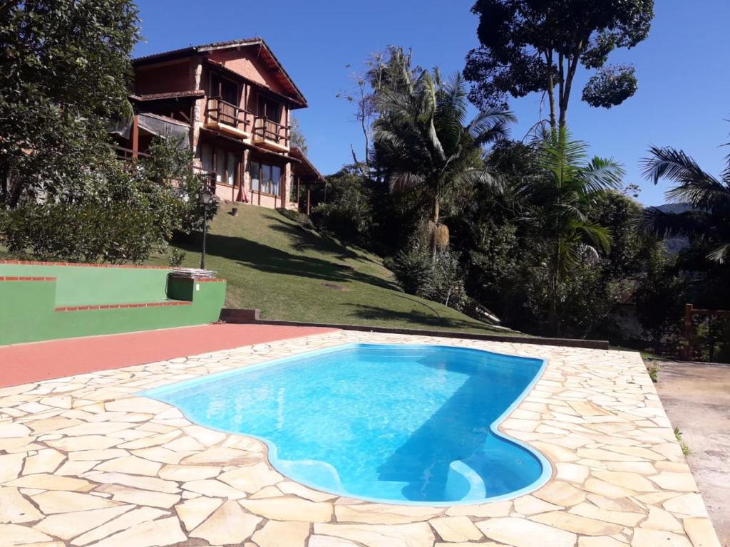una piscina frente a una casa en Casa com churrasqueira piscina privativa em São Pedro da Serra - Perto de Lumiar en Nova Friburgo