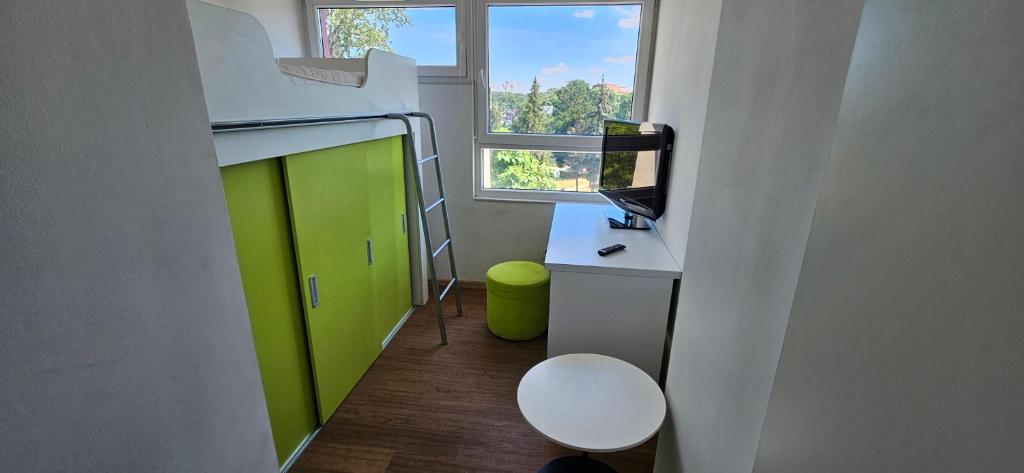 Pokój z zielonymi drzwiami i biurkiem z komputerem w obiekcie Starter 1 we Wrocławiu