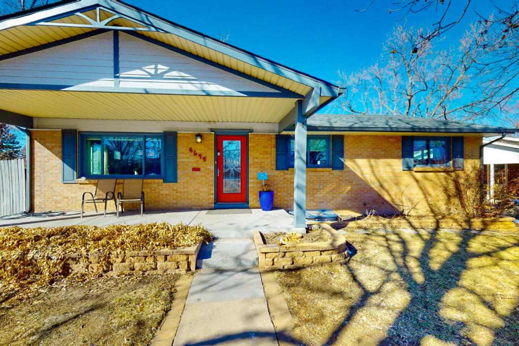 uma casa de tijolos com uma porta vermelha e uma entrada em Red Rocks Retreat em Englewood