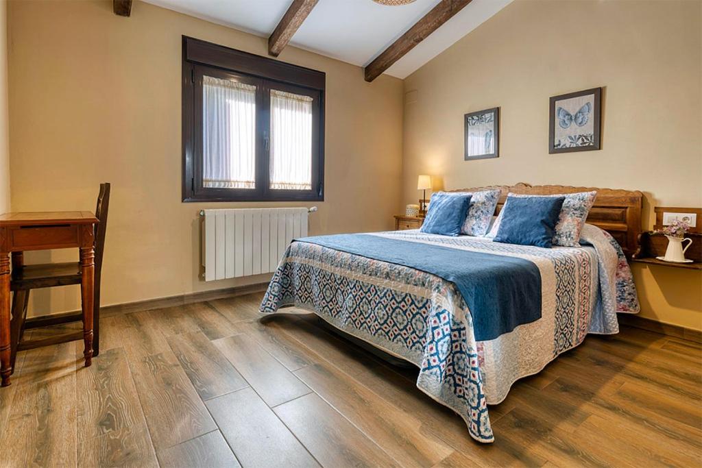 sypialnia z łóżkiem, stołem i oknem w obiekcie Apartamentos rurales Alameda del Jerte w mieście El Torno