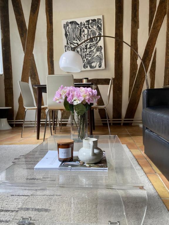 uma sala de estar com uma mesa de vidro com flores em Appartement Paris rue Montorgueil em Paris