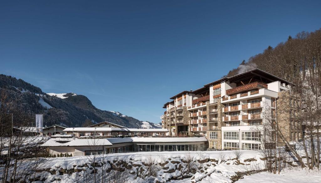 a large apartment building in the mountains with snow at Grand Tirolia Kitzbühel - Member of Hommage Luxury Hotels Collection in Kitzbühel