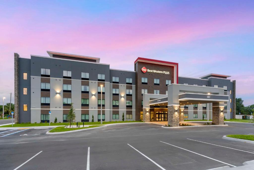 Un gran edificio con un estacionamiento enfrente. en Best Western Plus Winter Haven Inn &amp; Suites, en Winter Haven