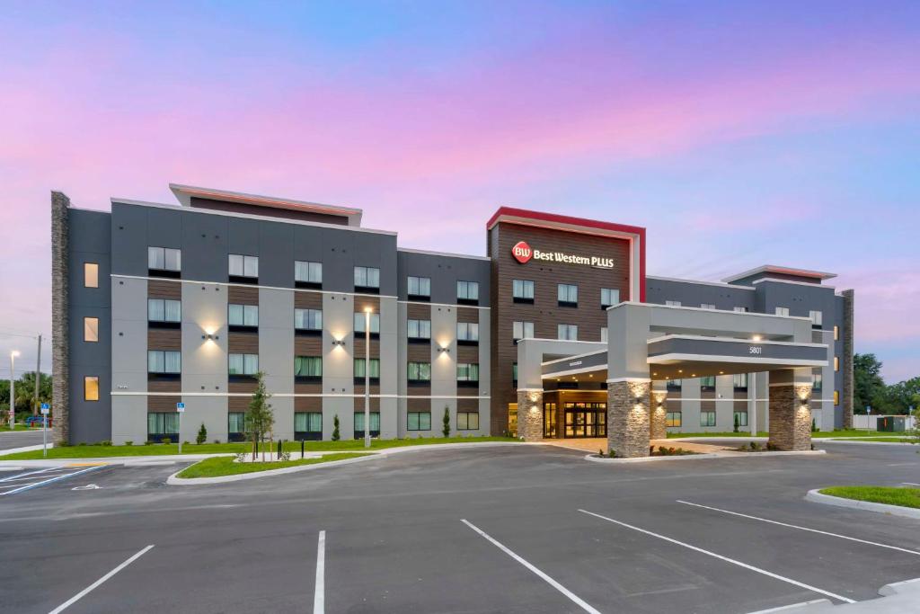 un gran edificio con un estacionamiento delante de él en Best Western Plus Winter Haven Inn & Suites en Winter Haven