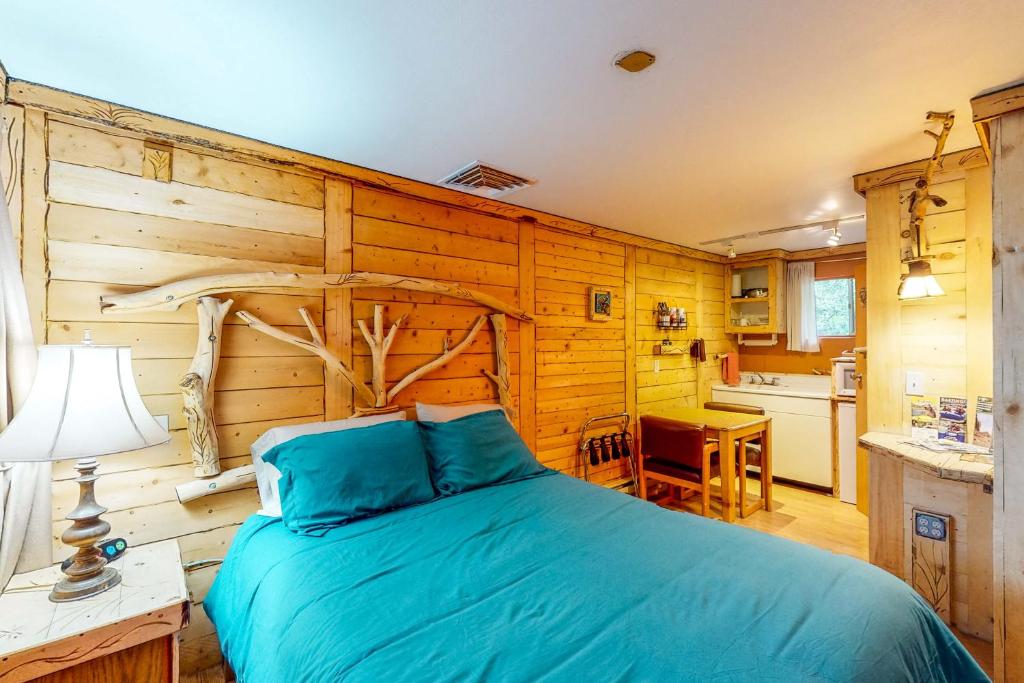 a bedroom with a bed with a wooden wall at Cedaredge Lodge, Cabin 3 in Cedaredge