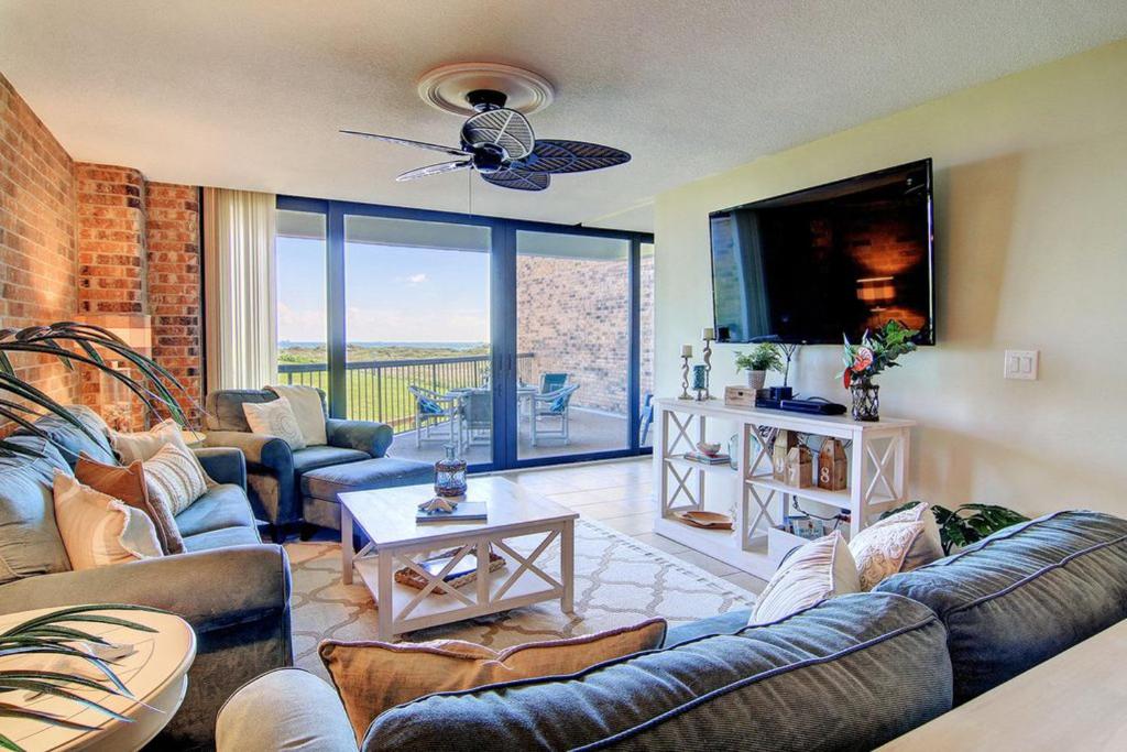 a living room with couches and a flat screen tv at Aransas Princess 112 in Port Aransas