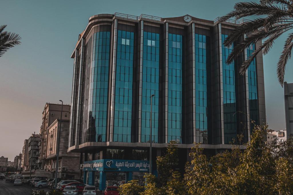 a large building with glass windows on a city street at مساكن المنى Al Mona Residences Serviced Apartments in Jeddah