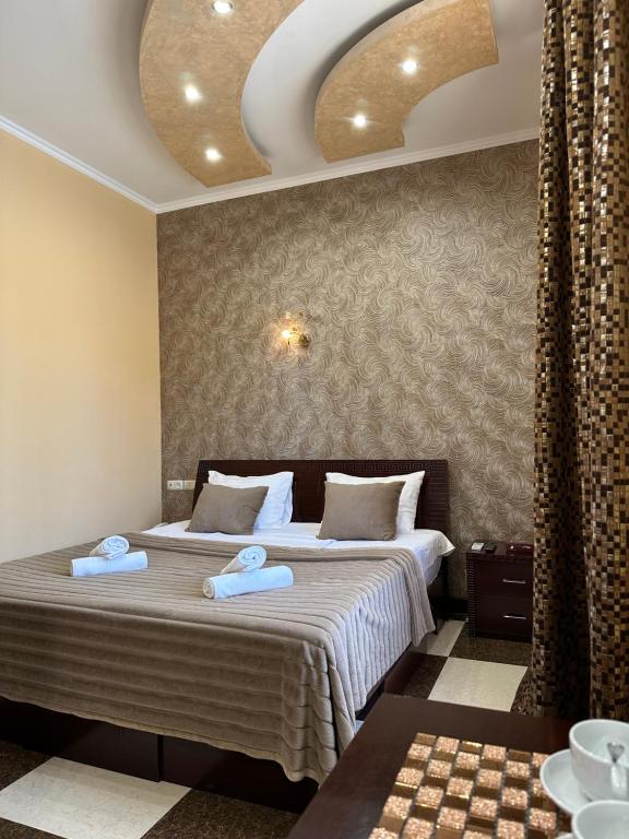 ein Schlafzimmer mit einem Bett mit zwei Handtüchern darauf in der Unterkunft Royal Plus Hotel in Yerevan