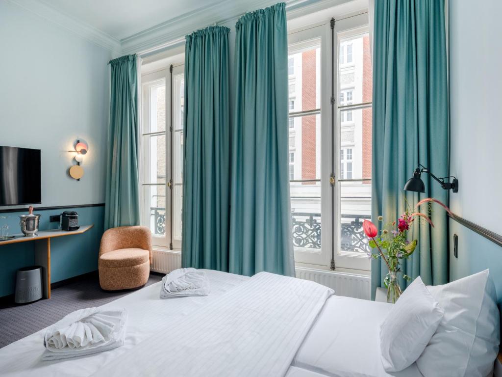 1 dormitorio con 1 cama grande y cortinas verdes en Aussen Alster Hotel, en Hamburgo