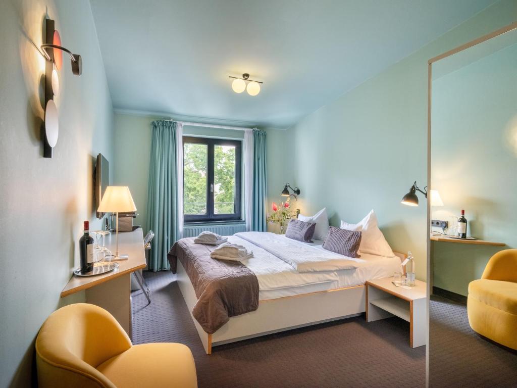 a bedroom with a bed and a mirror at Aussen Alster Hotel in Hamburg