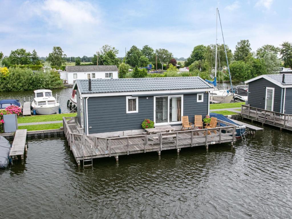 een klein huisje op een dok op een waterlichaam bij Grote Karekiet 24-22 in Breukelen