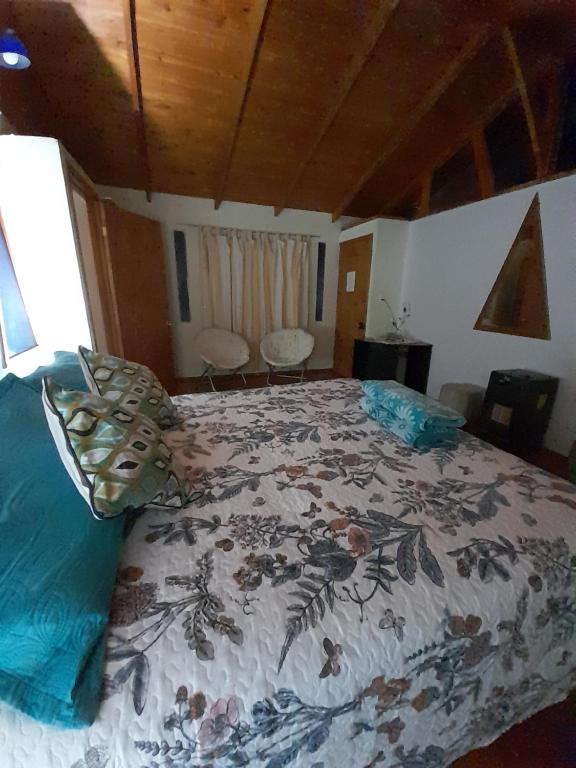 a bedroom with a bed with a comforter on it at Encanto Rural - Casa de campo para disfrutar y olvidar el estrés in Putaendo