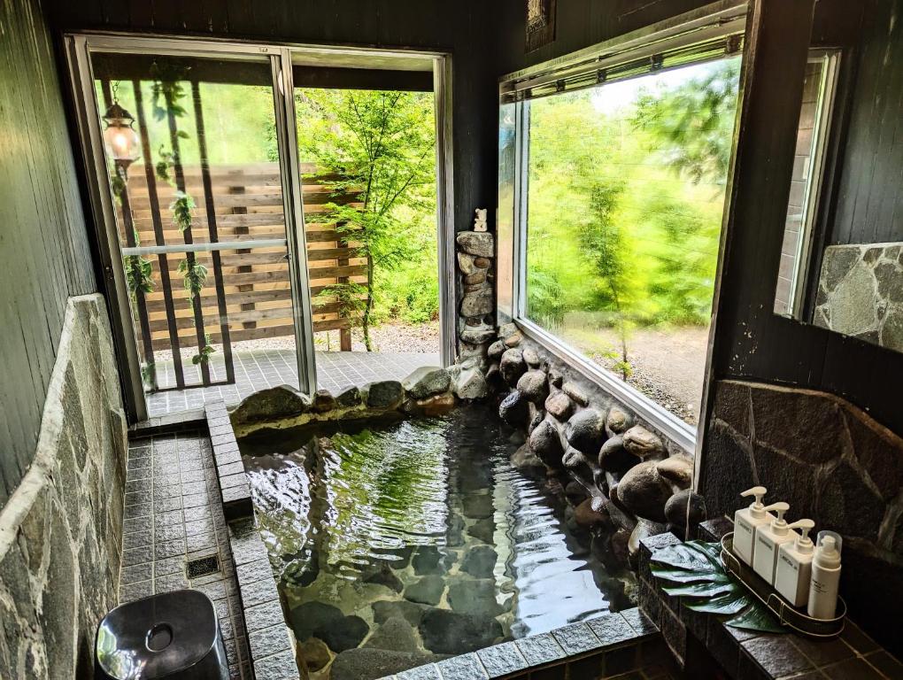um quarto com um lago no meio de uma casa em プライベート温泉付き隠れ家　Shankara Lodge ~stay & retreat~ em Kirishima