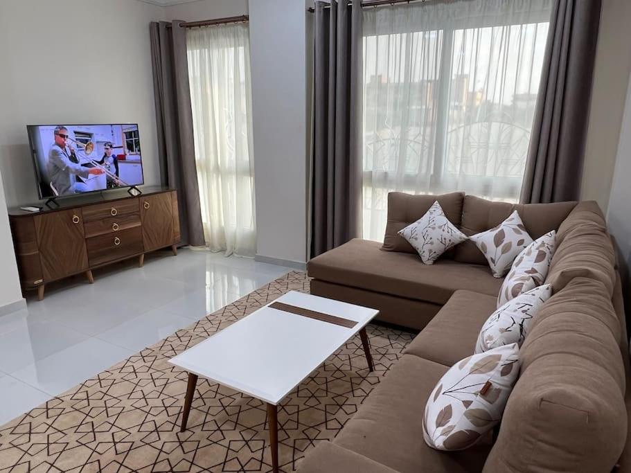 sala de estar con sofá y TV en شقه عصريه, en Madinat Al Ashir min Ramadan