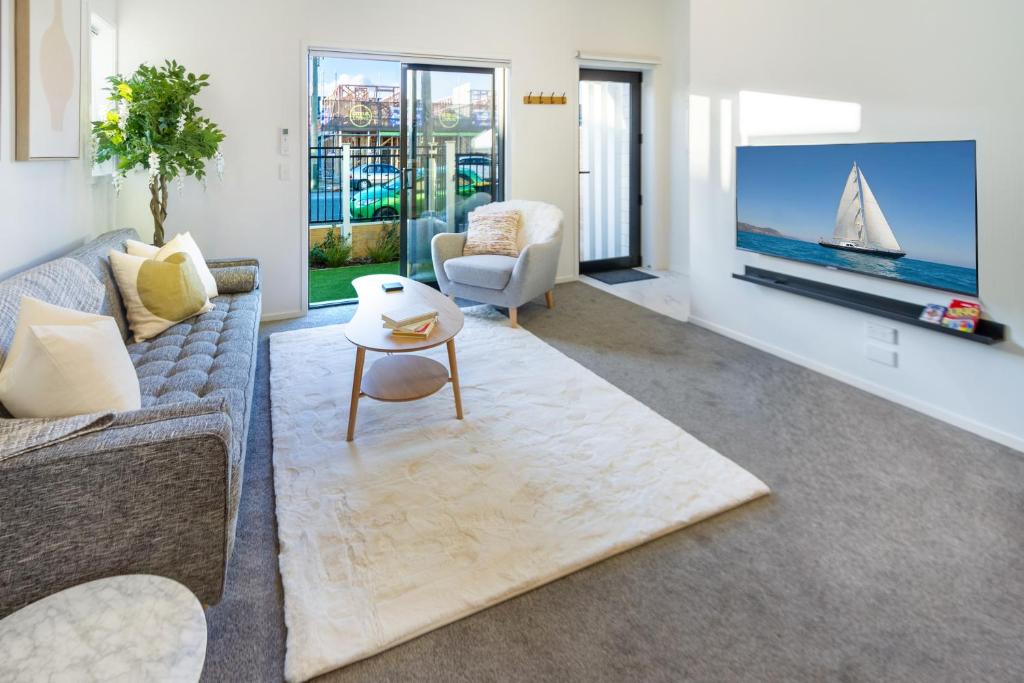 a living room with a couch and a tv at Large trendy 3 Bedroom Residence, Central City in Christchurch