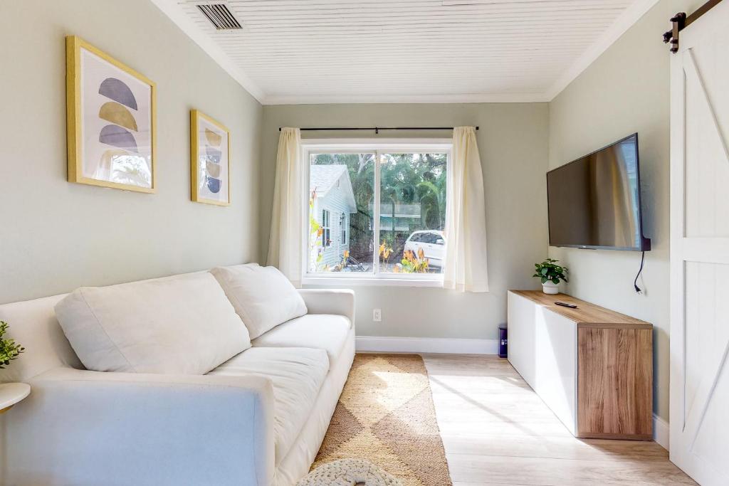 un salon avec un canapé blanc et une télévision dans l'établissement The Hideaway, à Fort Lauderdale