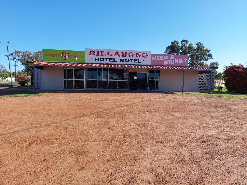 a hotel motel with a dirt field in front of it at Billabong Hotel Motel in Cunnamulla