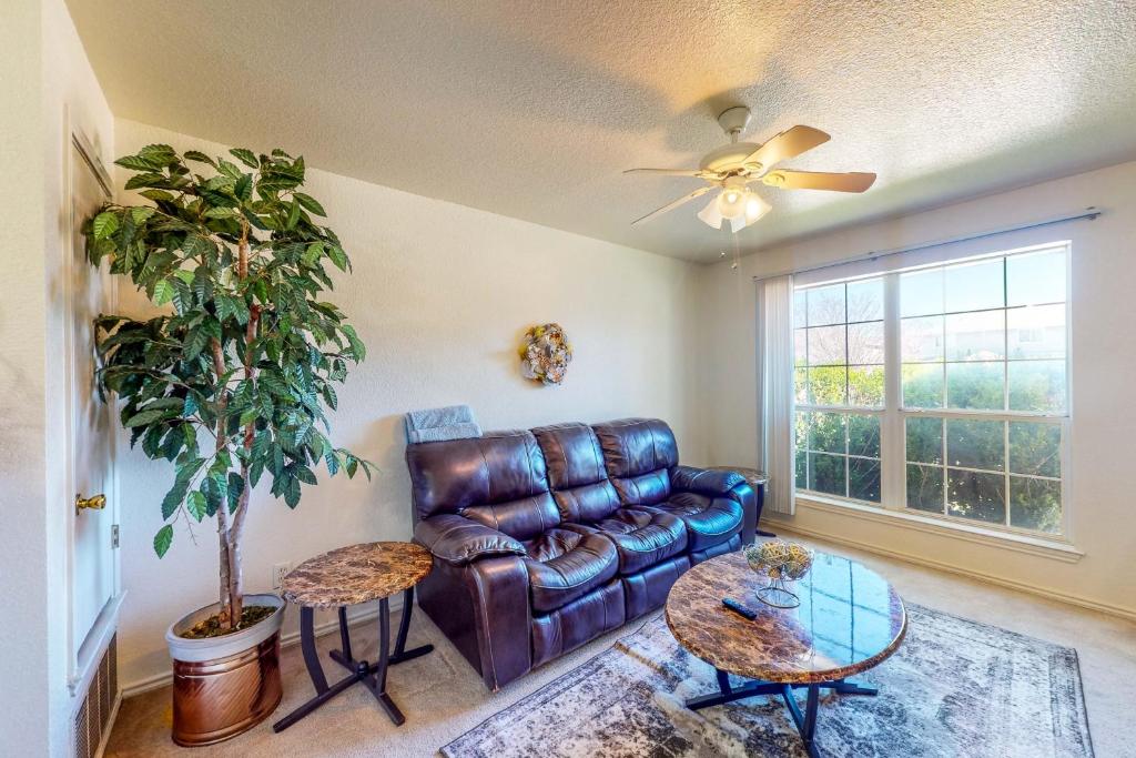 a living room with a leather couch and a table at It's Always Sunny in Killeen in Killeen