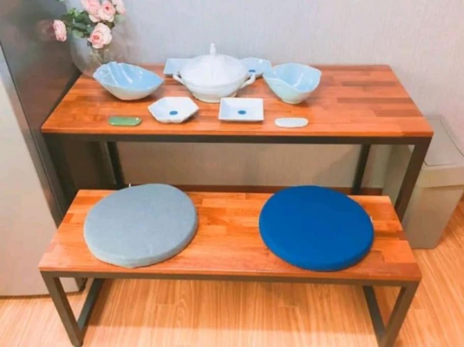 a wooden table with bowls and plates on it at SoGoBe Pension in Jeju