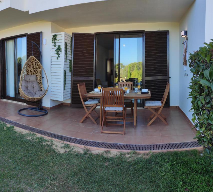 un patio con tavolo e sedie in legno di Palm House Alvor ad Alvor