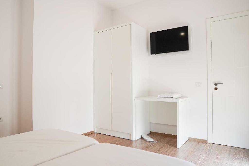 um quarto com paredes brancas e uma televisão na parede em Mega Hotel em Gjirokastër