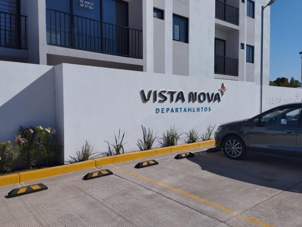 a car parked in a parking lot in front of a building at Departamento Vista Nova Culiacán in Casas