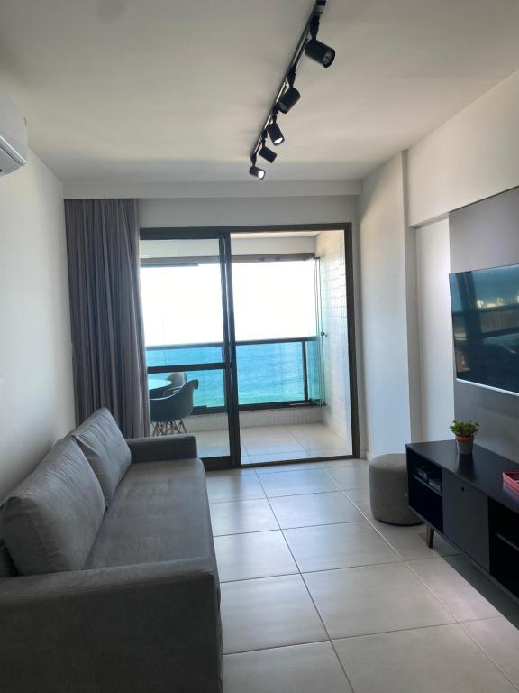ein Wohnzimmer mit Sofa und Fernseher in der Unterkunft Barra 535 Vista Mar in Salvador