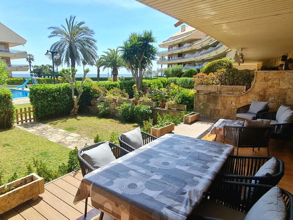 eine Terrasse mit Tisch und Stühlen auf einem Deck in der Unterkunft Apartaments Marítim Torre Valentina in Sant Antoni de Calonge