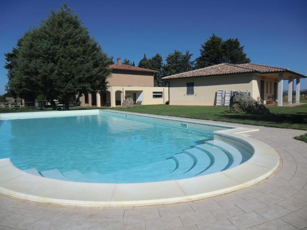 a swimming pool in front of a house at Agriturismo Cavallin Del Bufalo in Manciano