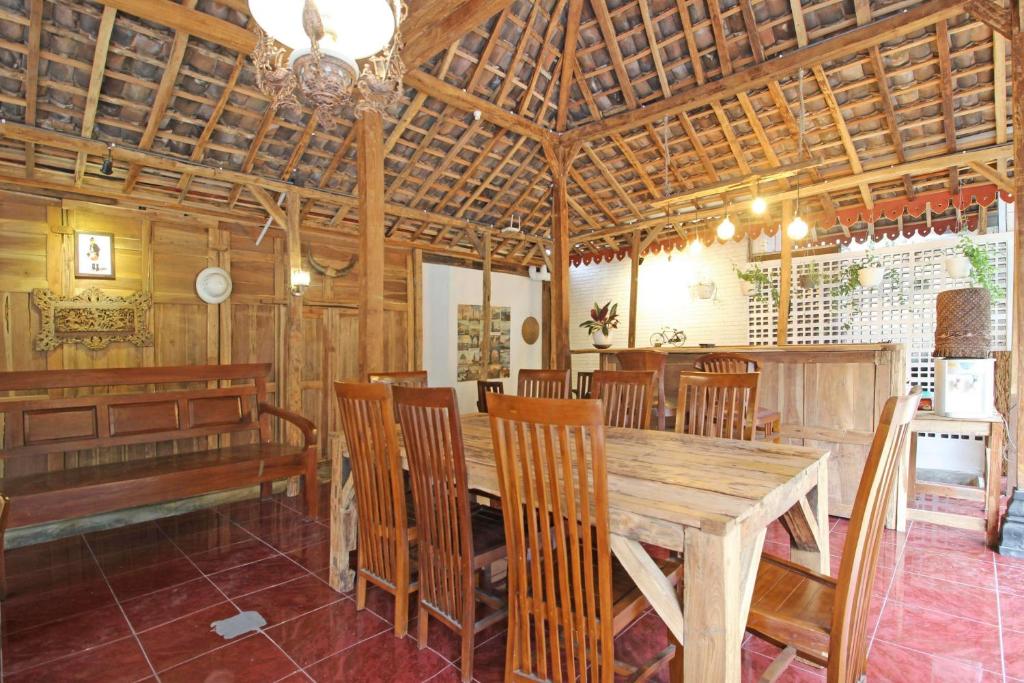 a dining room with a wooden table and chairs at RedDoorz near Pojok Beteng Prawirotaman in Yogyakarta