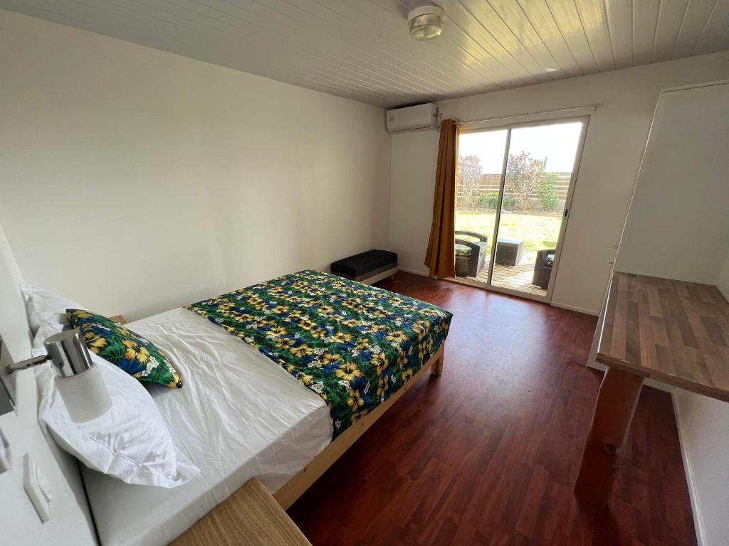 a bedroom with a bed and a large window at Te Mao in Avatoru