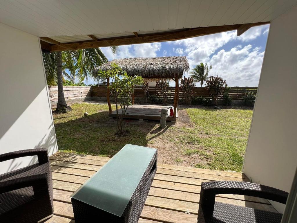 a porch with a table and chairs and a gazebo at Te Mao in Avatoru