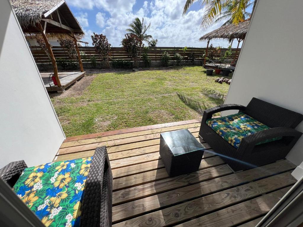 a balcony with a couch and a chair on a deck at Te Mao in Avatoru