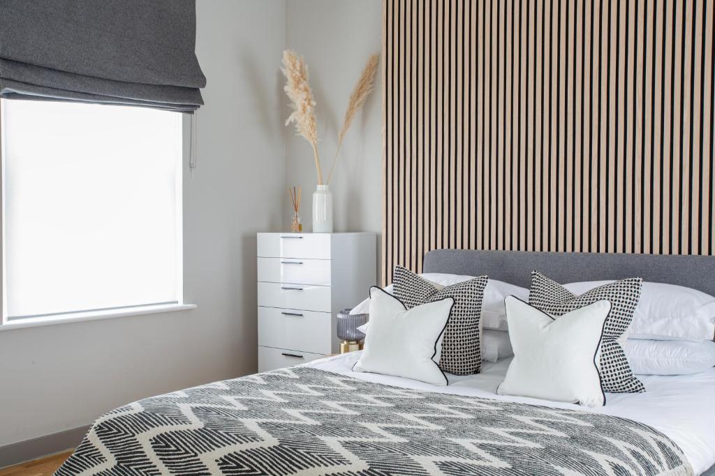 1 dormitorio con cama con almohadas y ventana en Eden Grove - Islington - Studio Apartment, en Londres
