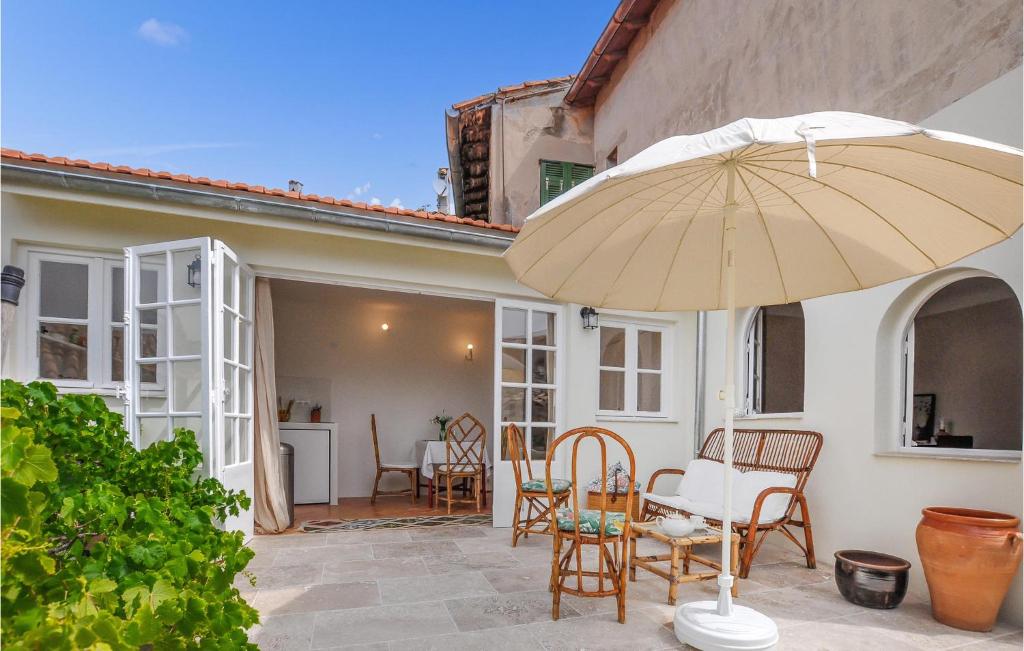 un patio avec une table, des chaises et un parasol dans l'établissement Cozy Apartment In Roquebrune-Cap-Martin, à Roquebrune-Cap-Martin