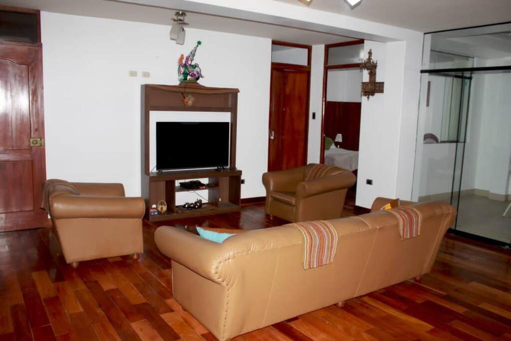 sala de estar con sofá y TV en La Casa Central d' Ana - Departamento amoblado, en Cajamarca