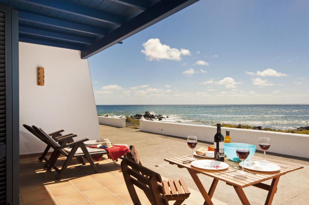 um pátio com uma mesa e cadeiras e o oceano em Casita Lanzaocean view em Punta Mujeres