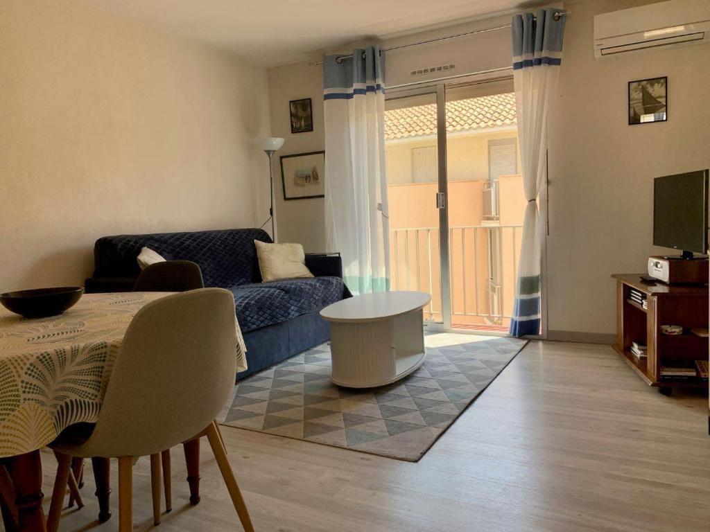 un salon avec un canapé et une table dans l'établissement Appartement à 2 pas de la plage de Mèze, climatisé, parking gratuit, labelisé 2 clés CLEVACANCES - FR-1-604-40, à Mèze