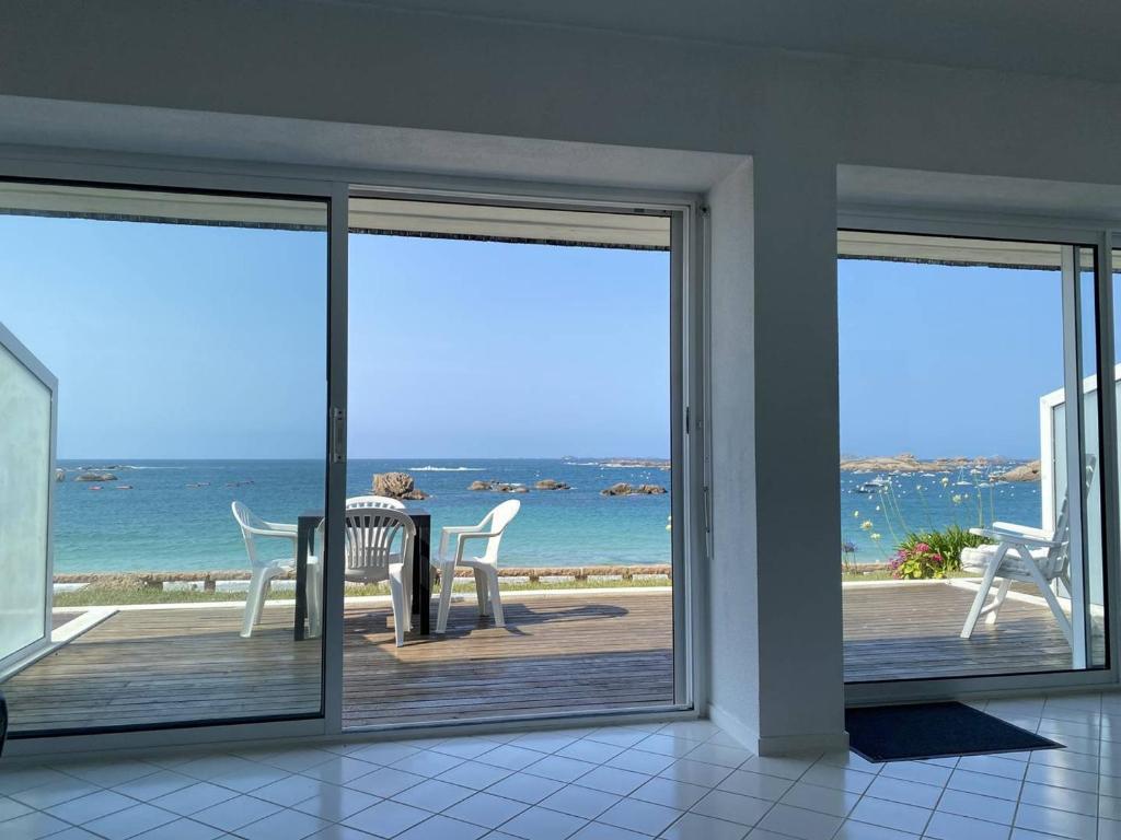 une chambre avec un balcon avec une table et des chaises dans l'établissement Appartement avec terrasse, accès direct plage, parking privé - FR-1-368-396, à Trégastel