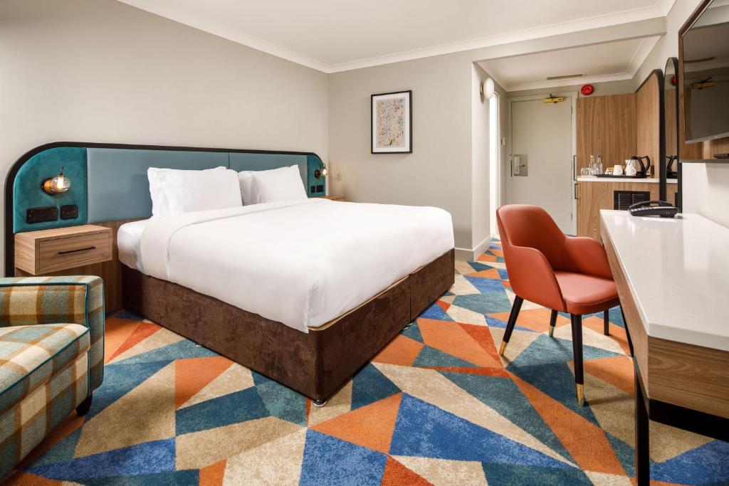ウォリックにあるDelta Hotels by Marriott Warwickのベッドとキッチン付きのホテルルーム