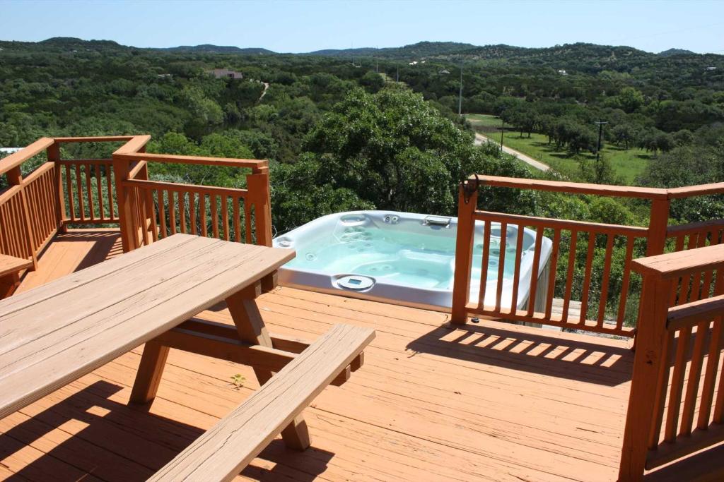 a deck with a bench and a jacuzzi tub at Rockin' B Ranch Bluff House in Pipe Creek